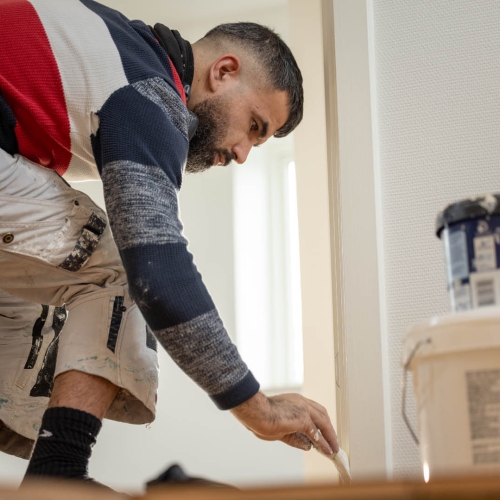 Maling af flyttelejlighed i Odense – maler arbejder med maling af panel.
